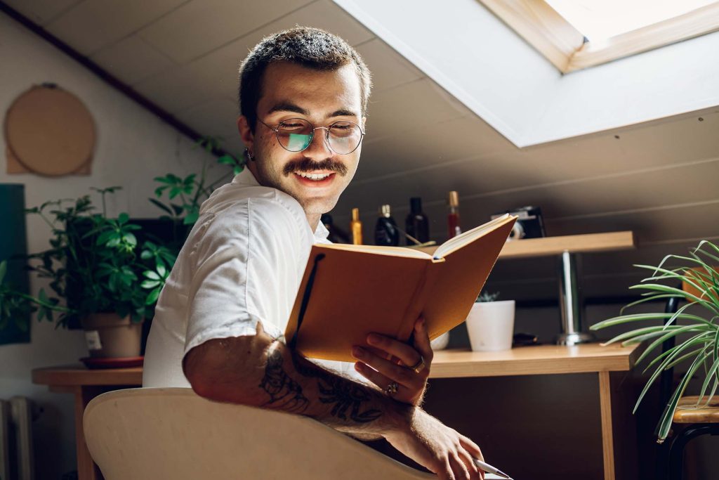 fashionable-hipster-man-with-mustache-reading-a-bo-LT72SJC.jpg